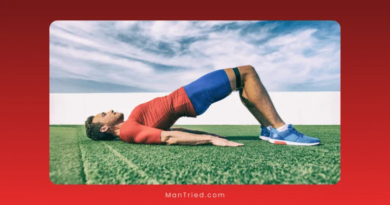 A man in athletic clothes performs a glute bridge exercise, often used for male kegel exercises, on artificial grass outdoors, with a resistance band above his knees and a blue sky in the background.