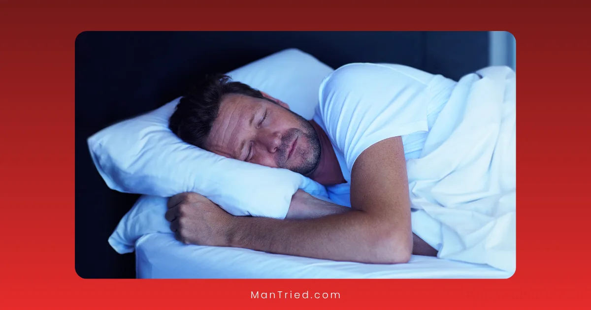 A man with short hair and stubble is sleeping peacefully on his side in bed, hugging a white pillow. Quality sleep can help boost testosterone. The background is dark, and the image has a red border.