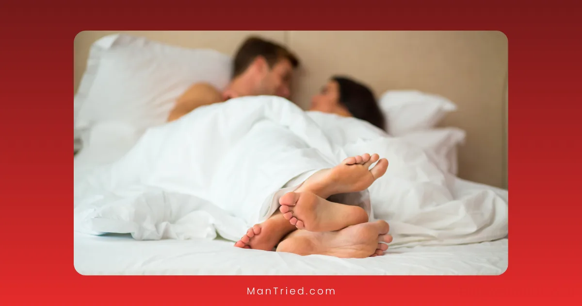 A couple lies in bed under white sheets, facing each other and partially covered, their bare feet visible in the foreground. The image, bordered in red, subtly hints at the intimacy of the stop-start technique.