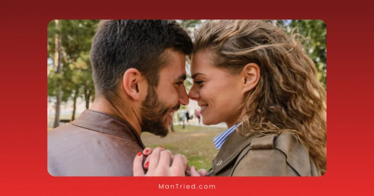 A smiling couple stands close together outdoors, touching foreheads and looking into each other's eyes, holding hands with trees in the background—a tender moment that captures the intimacy often nurtured through sex therapy.