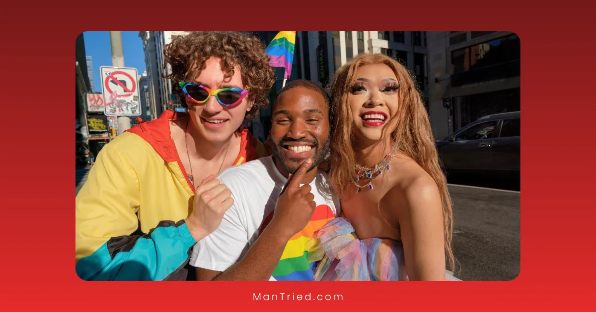 Three people smiling and posing together outdoors during a pride event, wearing colorful outfits and holding rainbow flags, celebrating LGBTQ+-affirming sexual health with city buildings in the background.