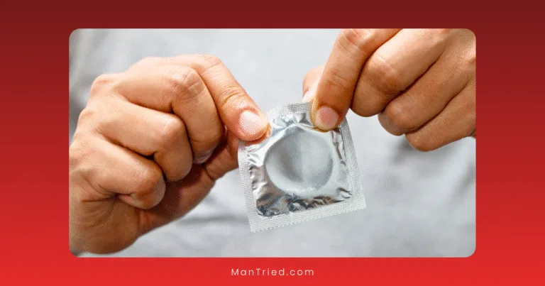 Close-up of hands holding a sealed condom packet, highlighting effective STI prevention methods, against a blurred background.