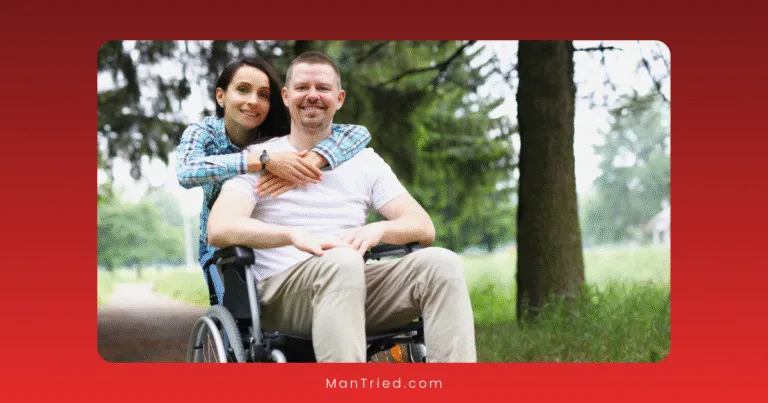 A smiling woman embraces a man seated in a wheelchair outdoors on a tree-lined path, both appearing happy. The image, bordered in red, highlights adaptive sexual techniques for men and support in relationships.