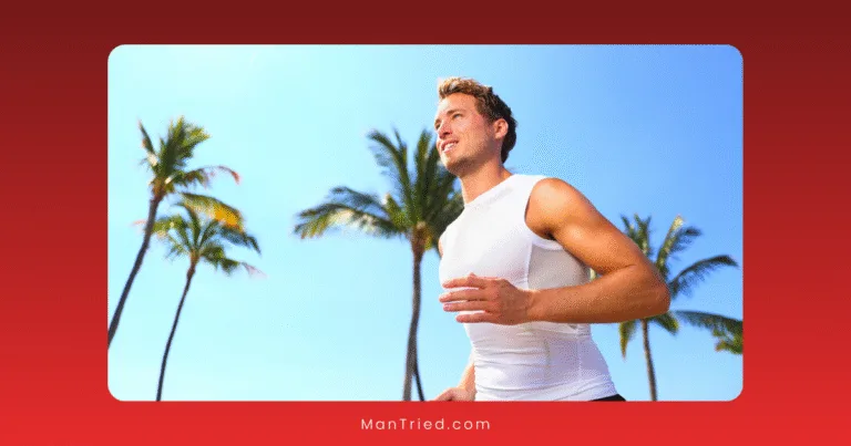 A man in a white sleeveless shirt jogs outdoors on a sunny day, getting in some cardio with palm trees and a clear blue sky behind him.