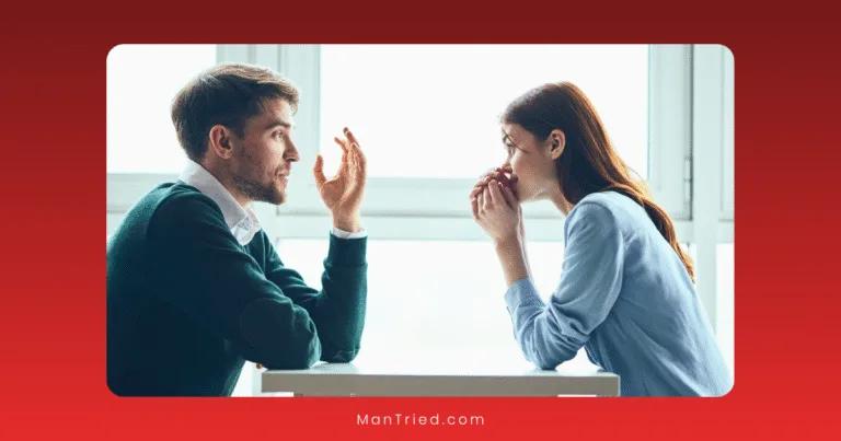 A man and woman sit across from each other at a table, having a serious conversation about communication for sexual problem. The man gestures with his hand while the woman listens intently, holding her hands near her face.