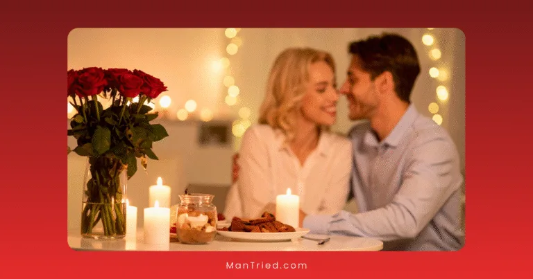 A couple sits closely together at a candlelit table, smiling and gazing at each other. With an intimacy menu of dessert and cookies, red roses, lit candles, and warm fairy lights in the background, romance fills the air.